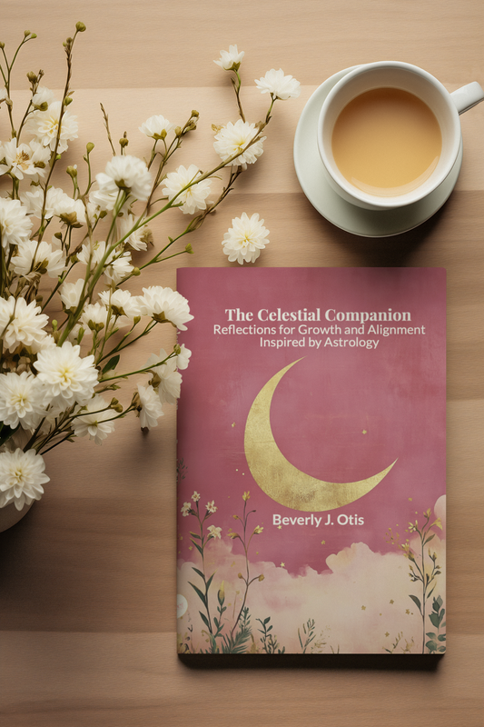 The Celestial Companion astrology journal by Beverly J. Otis displayed on a wooden table with white flowers and a cup of tea.